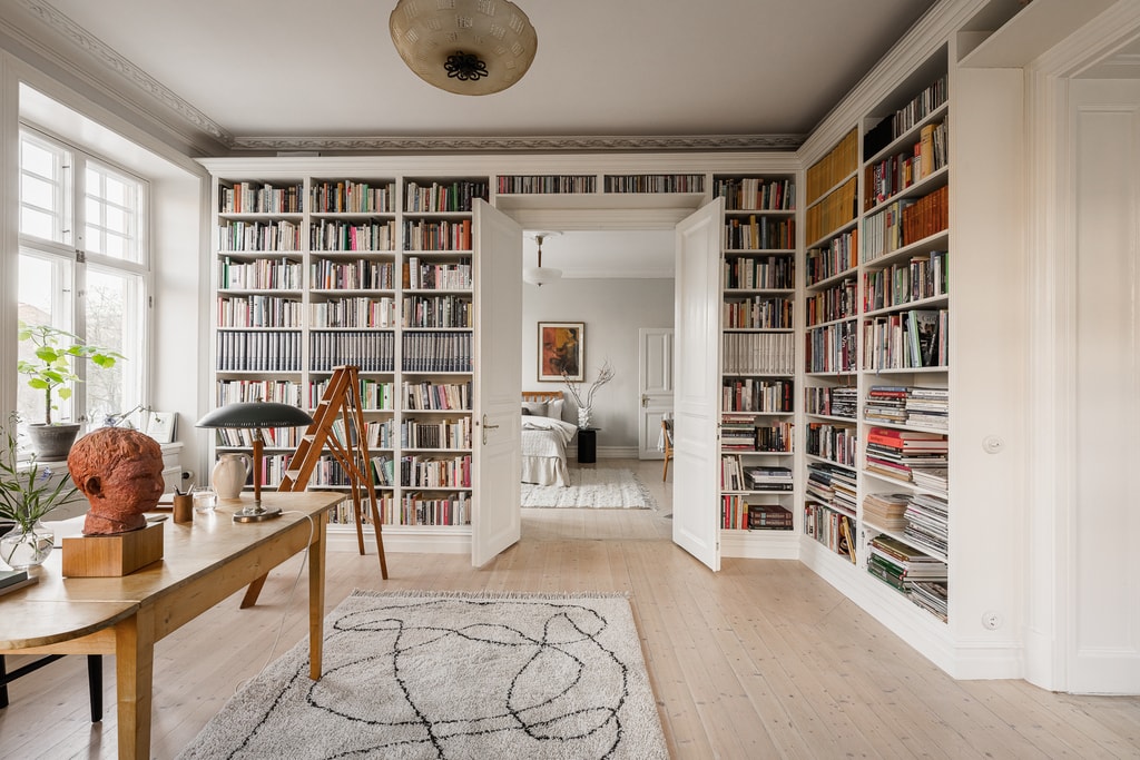 A Classic White Interior With An Impressive Bookshelf Around The Bedroom Doorway11.jpg