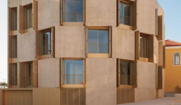 Aluminium shutters create “defensive” facade for Portuguese housing block