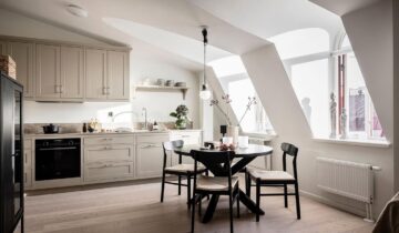 A modern attic apartment decorated in a beige and black palette