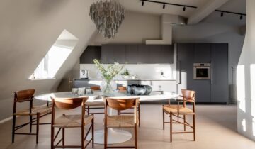 A modern attic loft with a gray kitchen and high-end furniture pieces