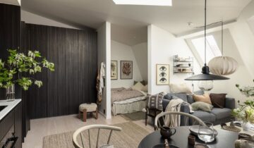 Attic studio home with a dark wood kitchen that continues into a wardrobe