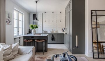 A historic apartment with a dark grey kitchen and elegant decor
