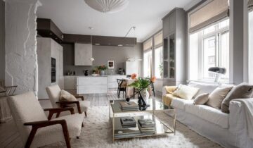 A modern kitchen and sage green bedrooms in a historic Swedish flat