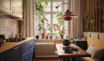 A studio apartment with a blue kitchen and custom room dividers