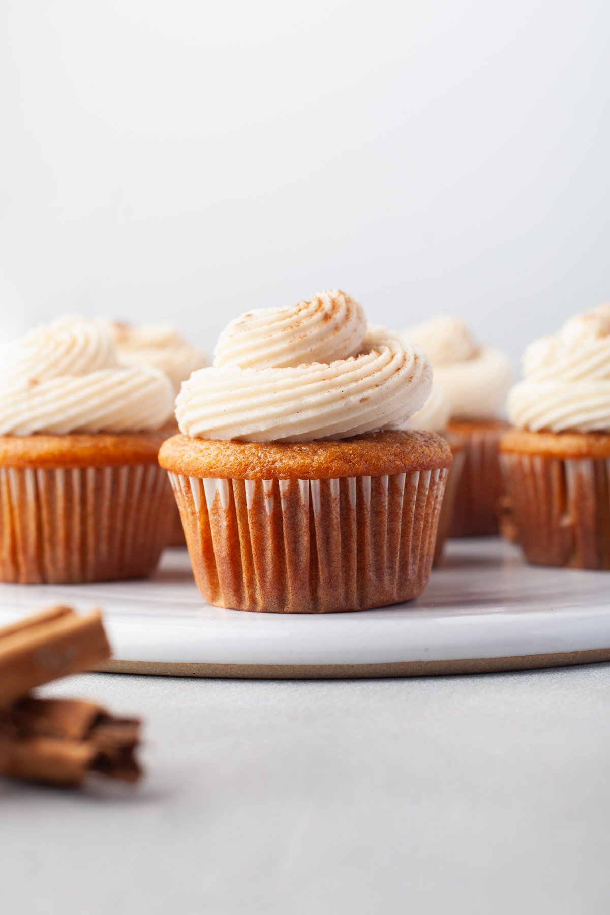 fall cupcakes on a plate with cream cheese frosting