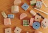 scattered wood blocks on a wood table with colored pencils