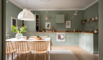 A historic home with a sage green kitchen with butcher block countertops