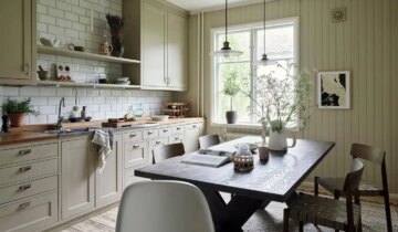 A muted beige kitchen and different wallpaper designs in a cozy Nordic apartment